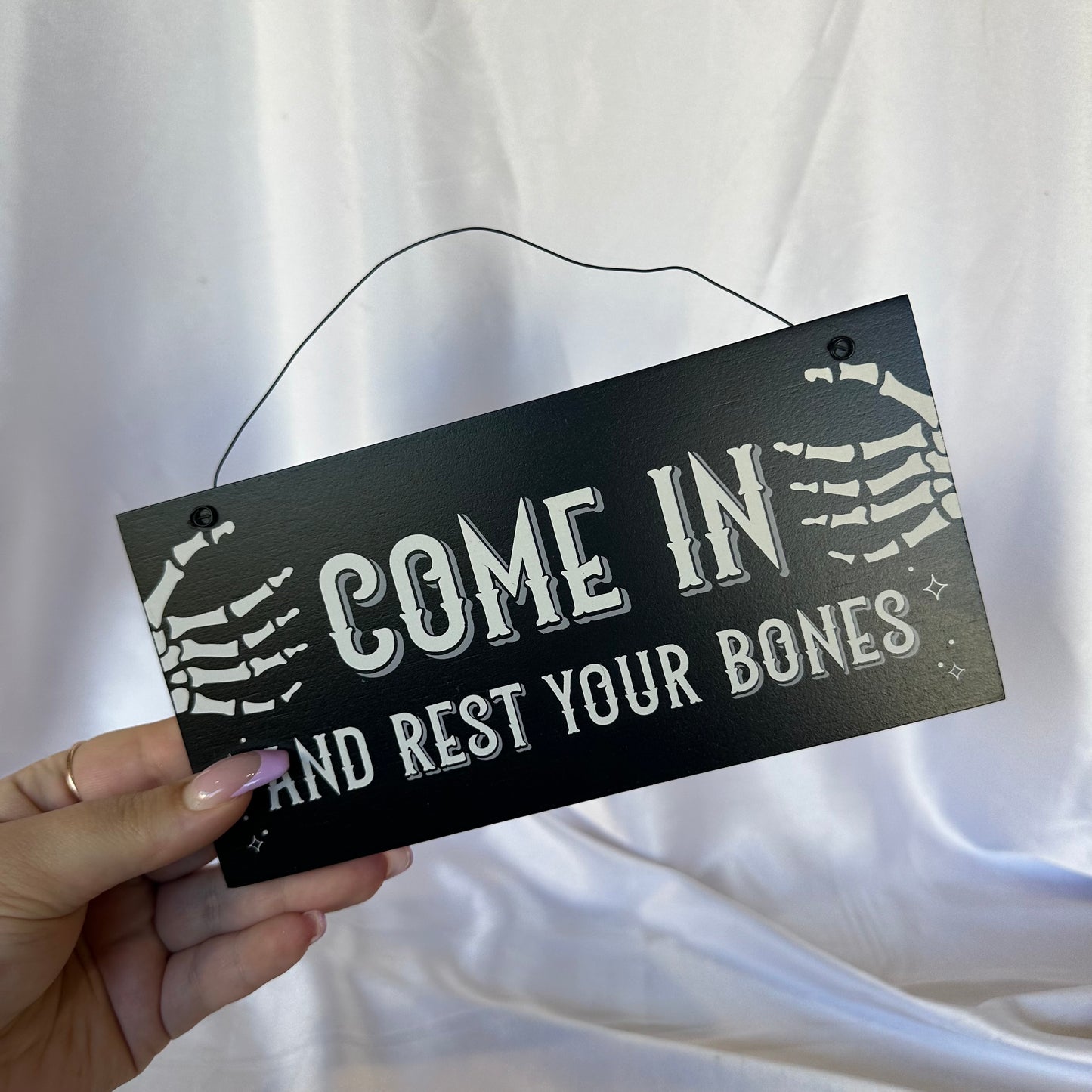 Come in and rest your bones sign